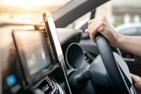 Male driver hand holding on steering wheel